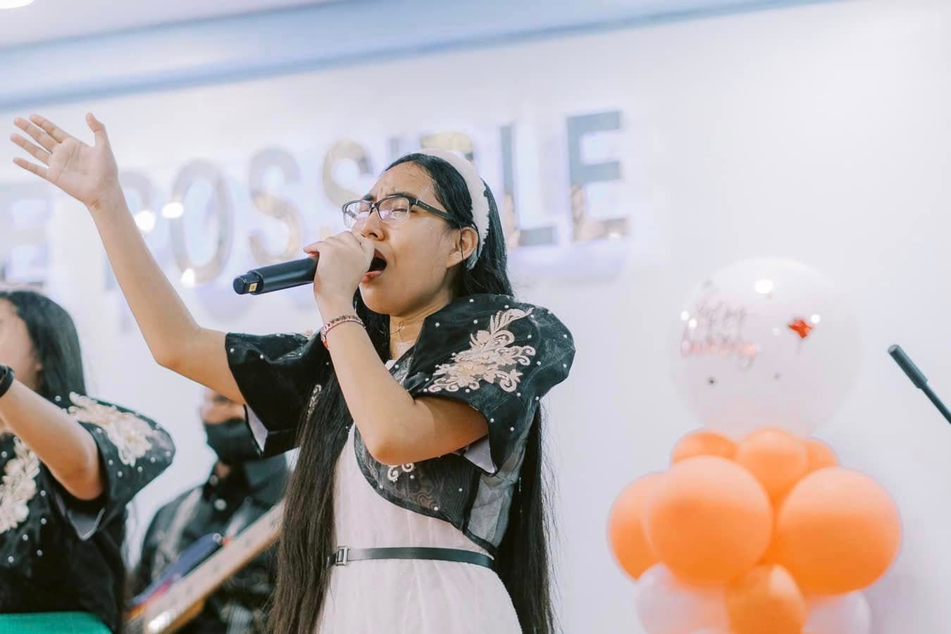 A worship team member singing passionately on stage