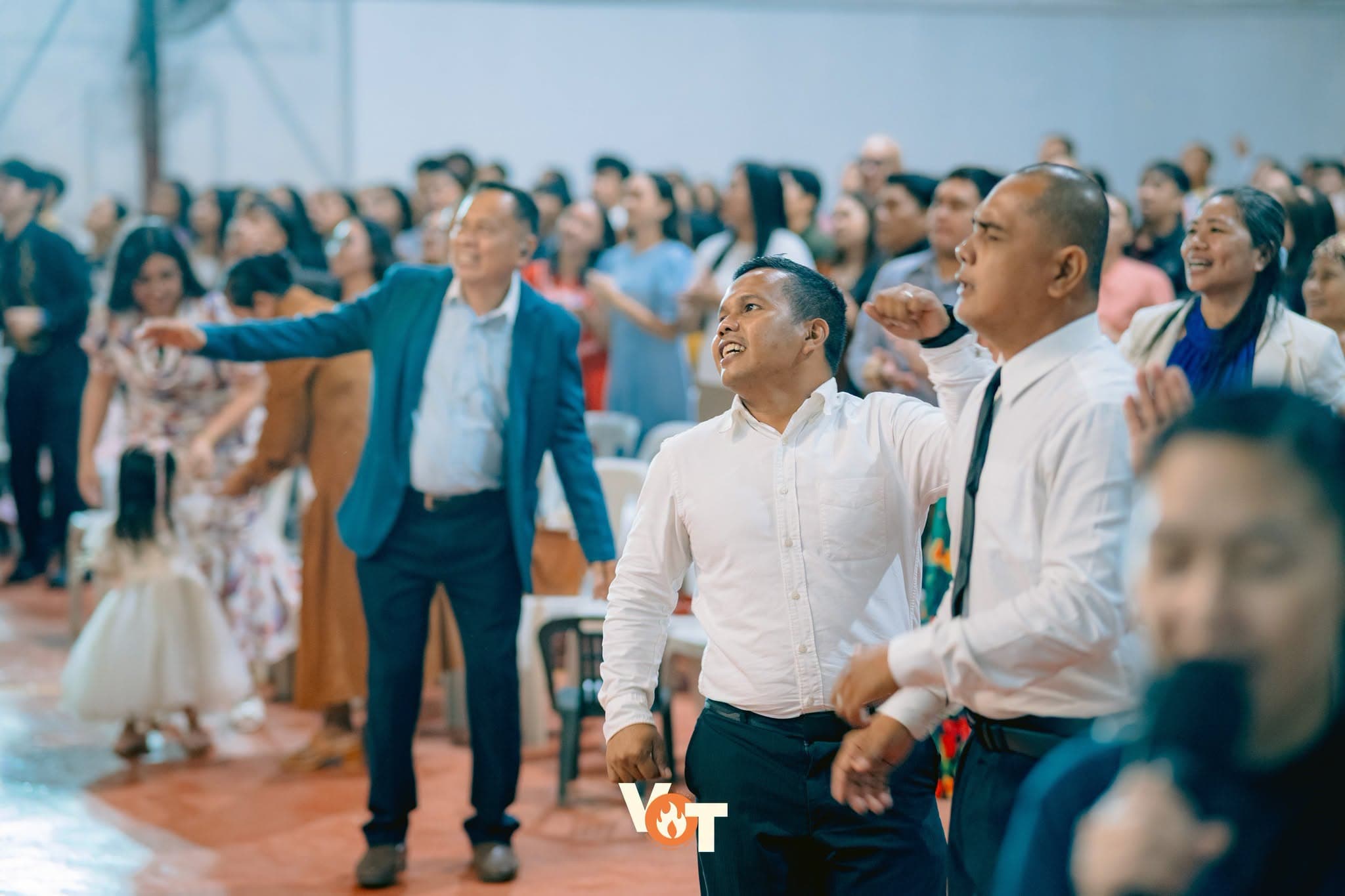 Members of the congregation worshiping with raised hands