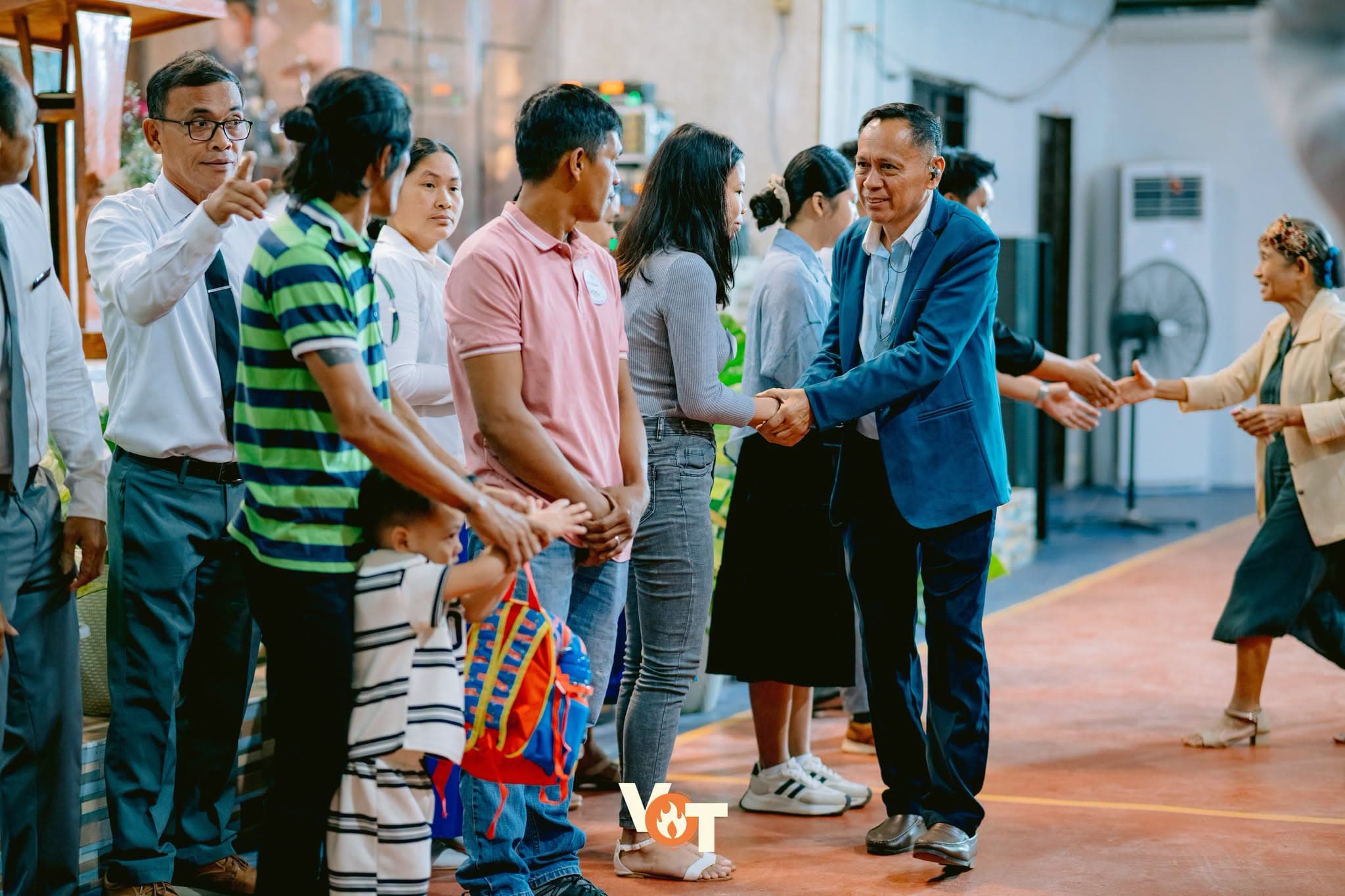 Pastor Mario Magno warmly greeting members of the congregation